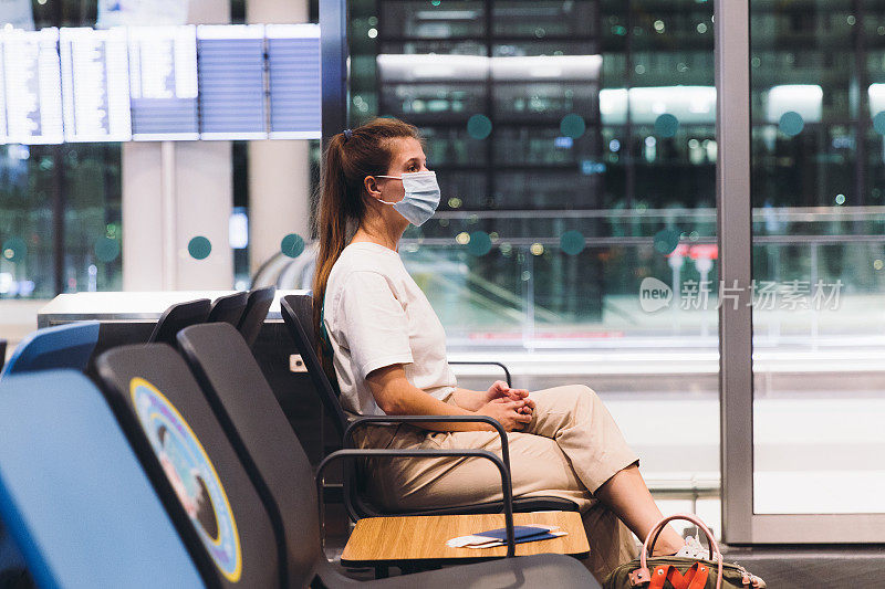 戴着防护面具的年轻女子在机场候机