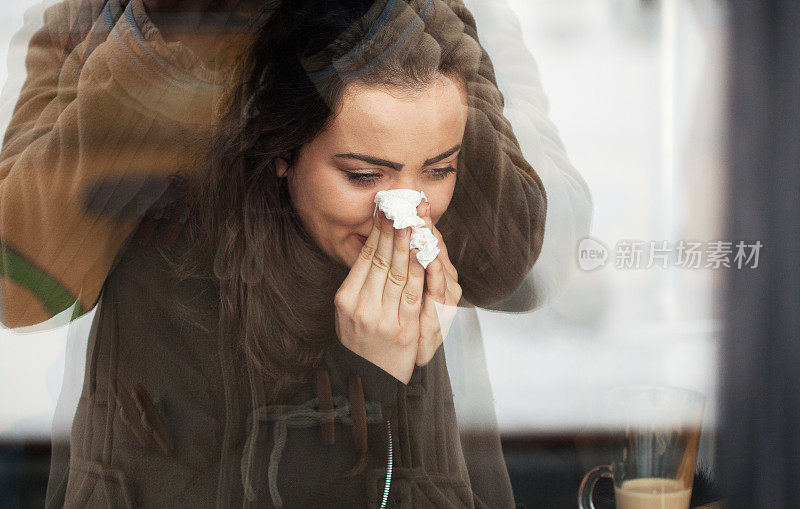 生病的年轻女子在擤鼻涕