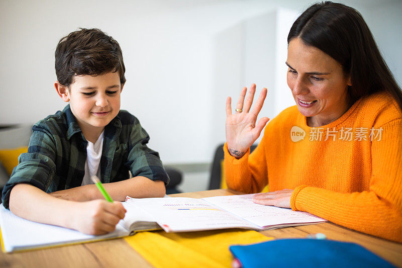 一个小男孩和他妈妈一起做作业