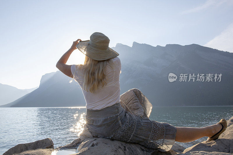 女人在山湖边休息，拍照