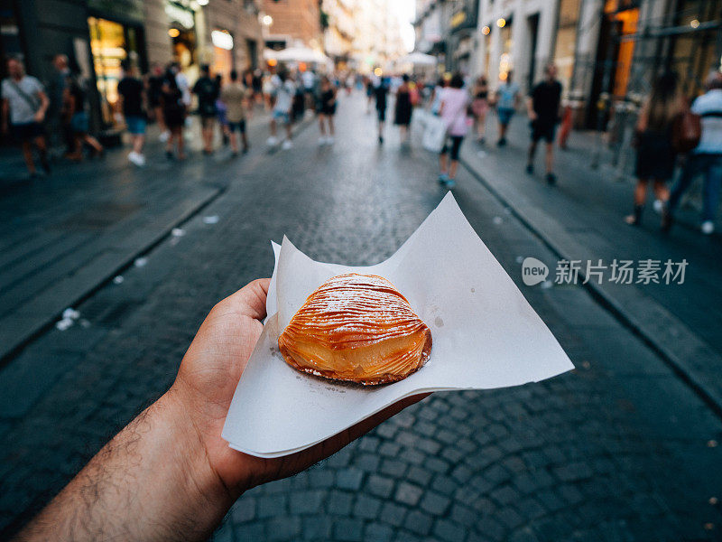 一个男人拿着一个典型的那不勒斯三明治