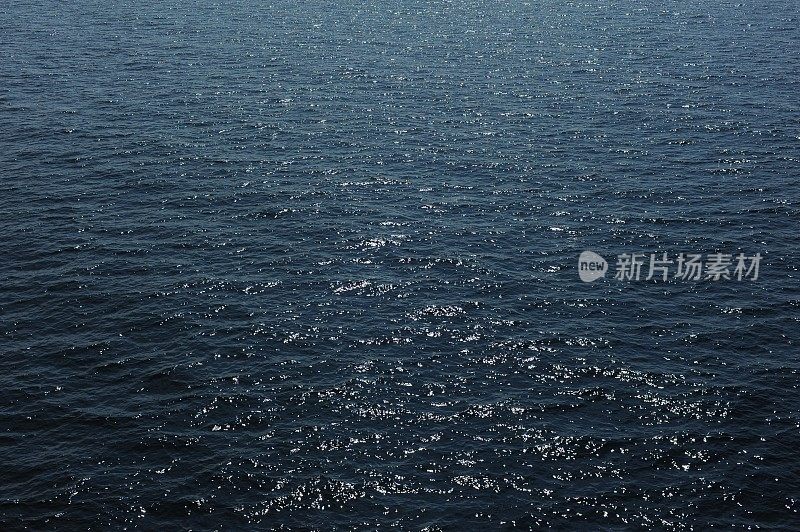 阳光下波光粼粼的蓝色海水和海水水面