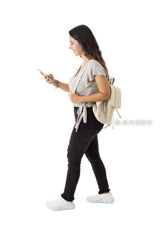 拉丁年轻女子一边走路一边用手机