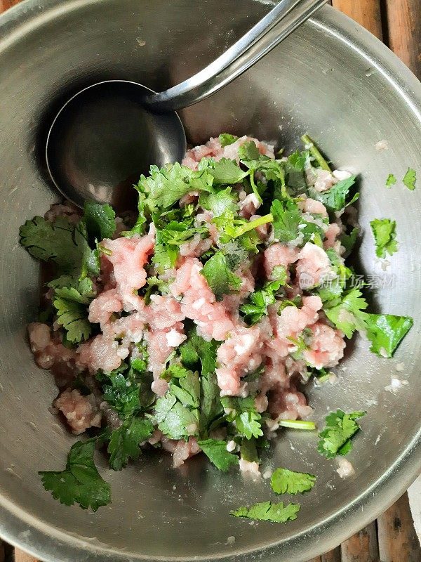 将香菜丝与猪肉末混合在碗中-食物的准备。