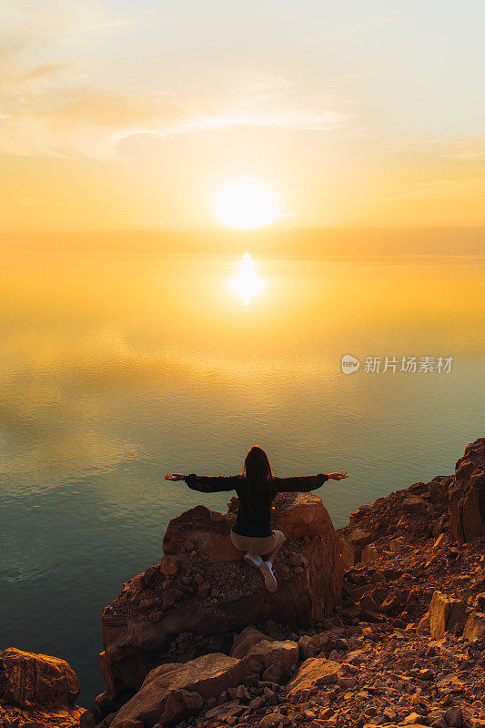 约旦死海上一个女人的剪影，她正在欣赏日落美景