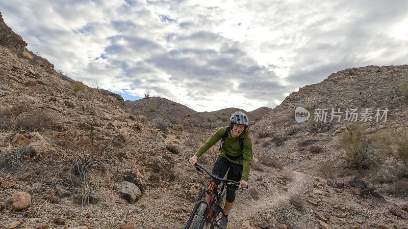 山地自行车手沿着沙漠小路行进