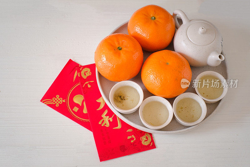 中国新年的节日概念。橘子、红包、金锭、白底茶壶。汉字“福”代表幸运