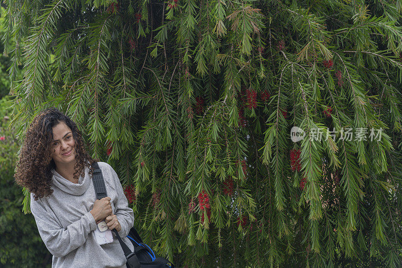 美丽的拉丁女人走在她的手提箱，她携带她的工具做瑜伽