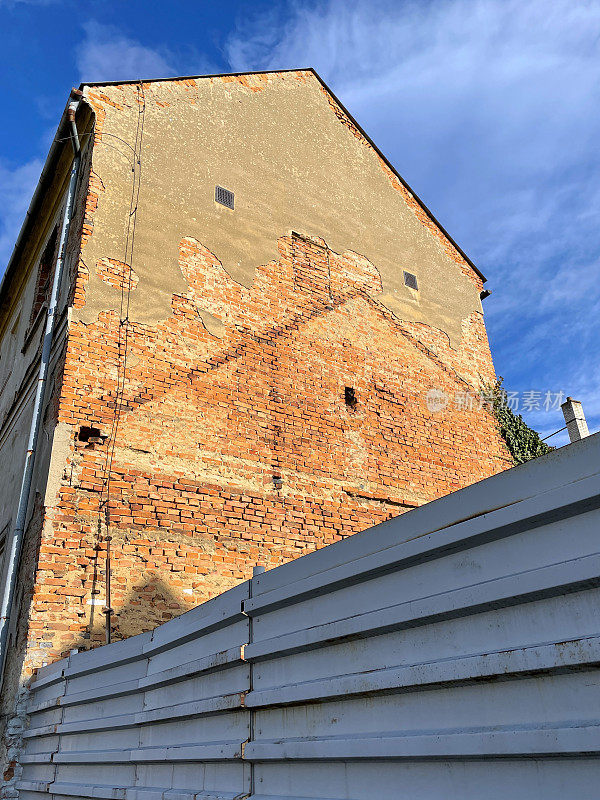 一堵旧砖墙，旁边有一所房子的痕迹，已经被拆除了。