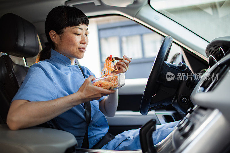 年轻的日本医护人员在车里吃午饭