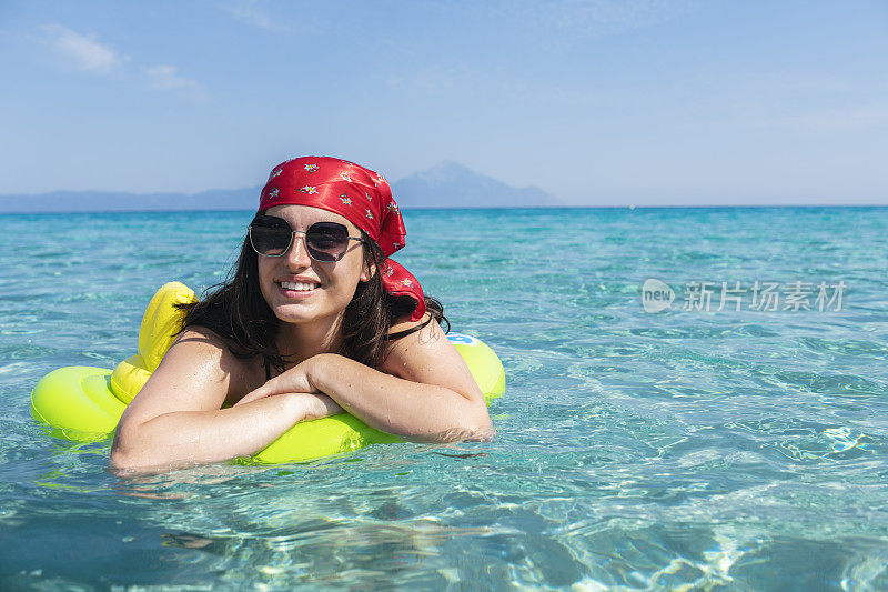 女子浮在充气床上的水面上。