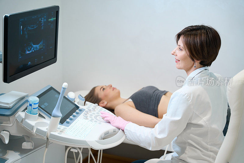 女医生为孕妇的胎儿做超声检查