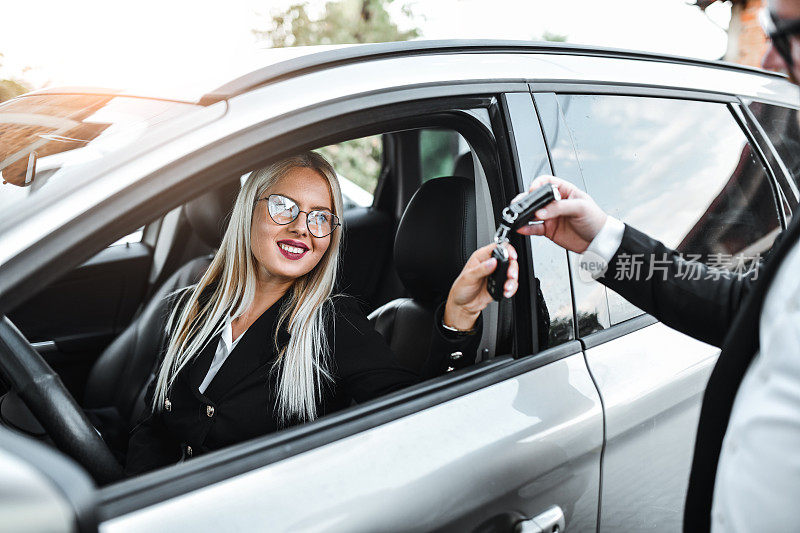 泊车员从漂亮的女商人那里拿钥匙停车