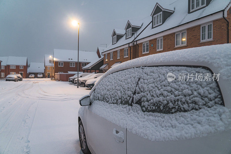 厚厚的积雪覆盖了街道、树篱、树木和停着的汽车