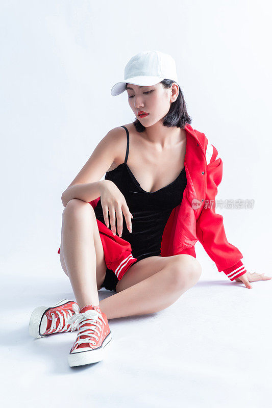 年轻的成年人的肖像迷人和性感漂亮的黑发拉拉队长女孩在黑色内衣和红色棒球夹克孤立的白色背景