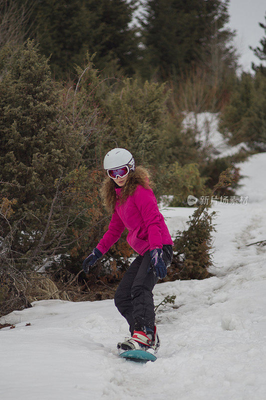 年轻女子在寒假里滑雪下山