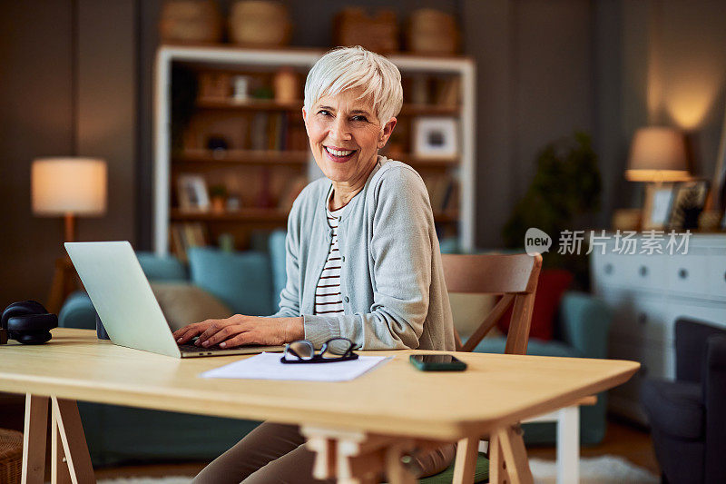 一个快乐的高级成年女性自由职业者的简介，在家工作，使用笔记本电脑