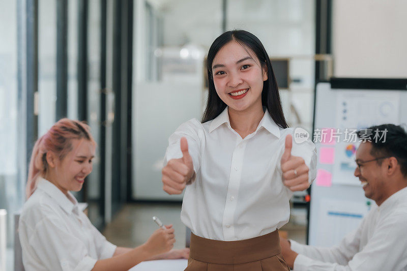 自信的年轻职业亚洲女商人在会议上竖起大拇指。积极反馈和协议概念。