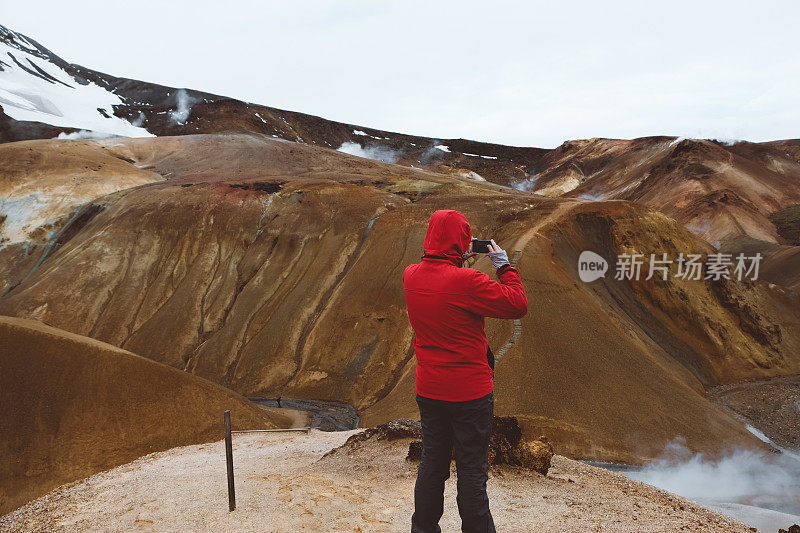 一名身穿红色夹克的男子在拍摄Kerlingarfj?ll冰岛火山景观
