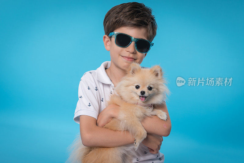 快乐的男孩和她的博美犬斯皮茨型狗
