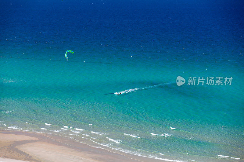 风筝冲浪在热带碧水海滩上从空中鸟瞰拍摄的照片