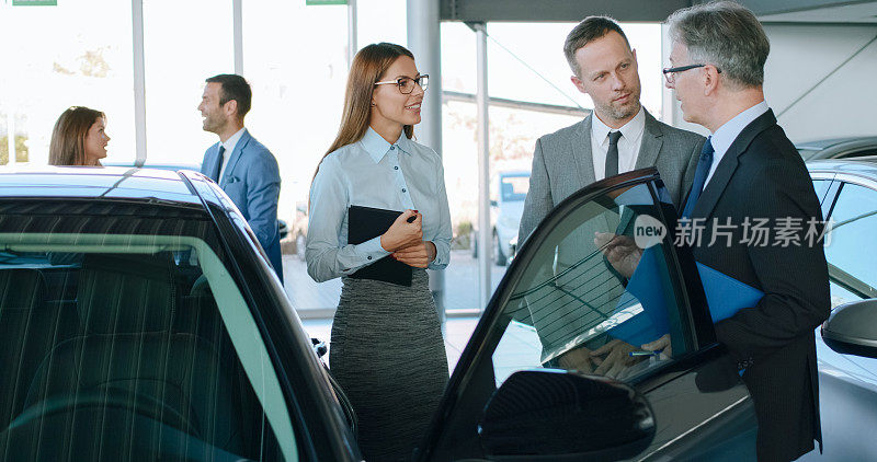 汽车销售人员在汽车经销商讨论业务策略
