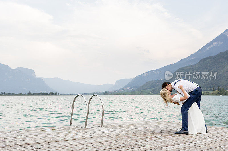 一对美丽的新婚夫妇在码头上接吻