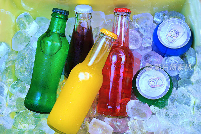 彩色苏打饮料和装满冰块的冷藏箱
