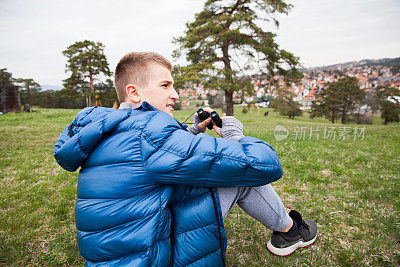 用望远镜看东西的青少年