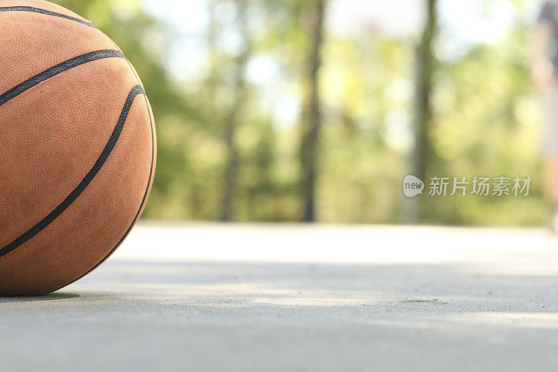 夏天，春天，男人在公园的室外球场上打篮球。