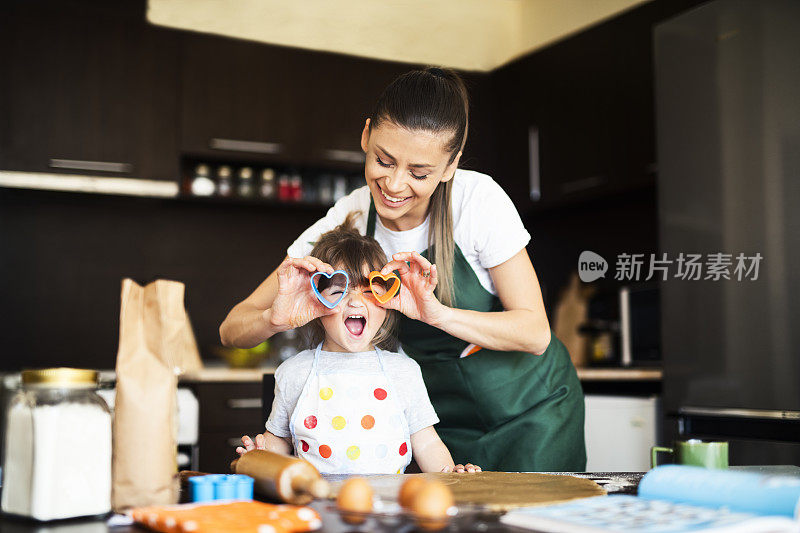 妈妈和可爱的小女儿玩得很开心，在厨房里做饼干