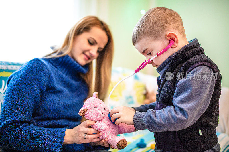 母亲和孩子玩得就像家里的医生