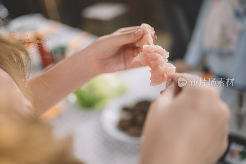 合上女人的手准备生鸡肉串