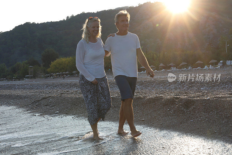日出时分，一对情侣在海滩上散步