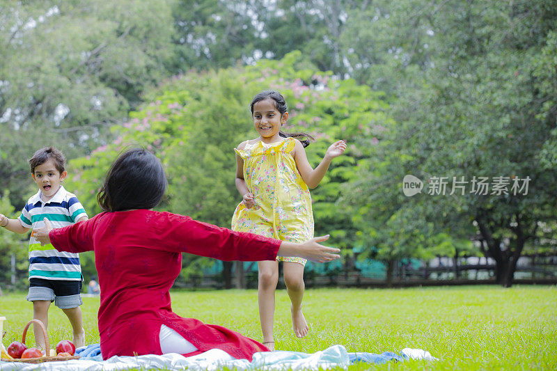 快乐的家庭享受野餐在自然在夏季股票照片