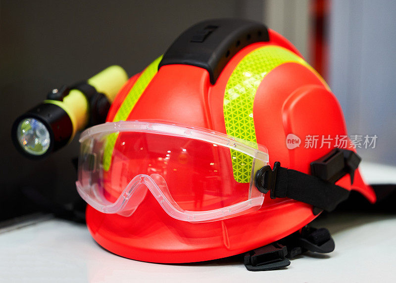 消防头盔与手电筒，特写。带前照灯的施工头盔