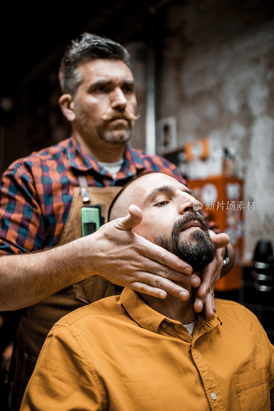 理发师在理发店里估计一个男人的胡子的长度和形状