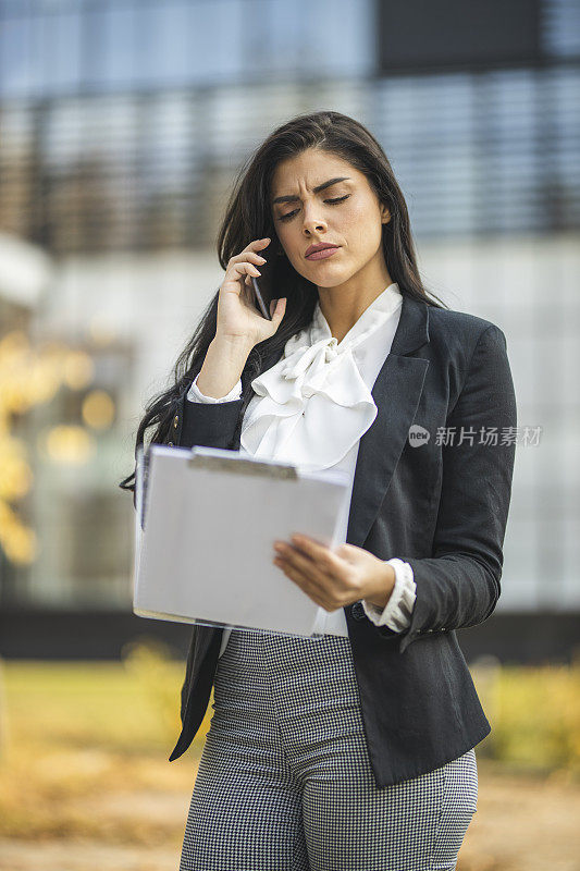 沮丧的女商人打电话检查文件