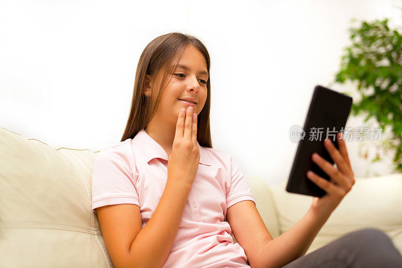 微笑的聋哑女孩在数字平板电脑上用手语交谈