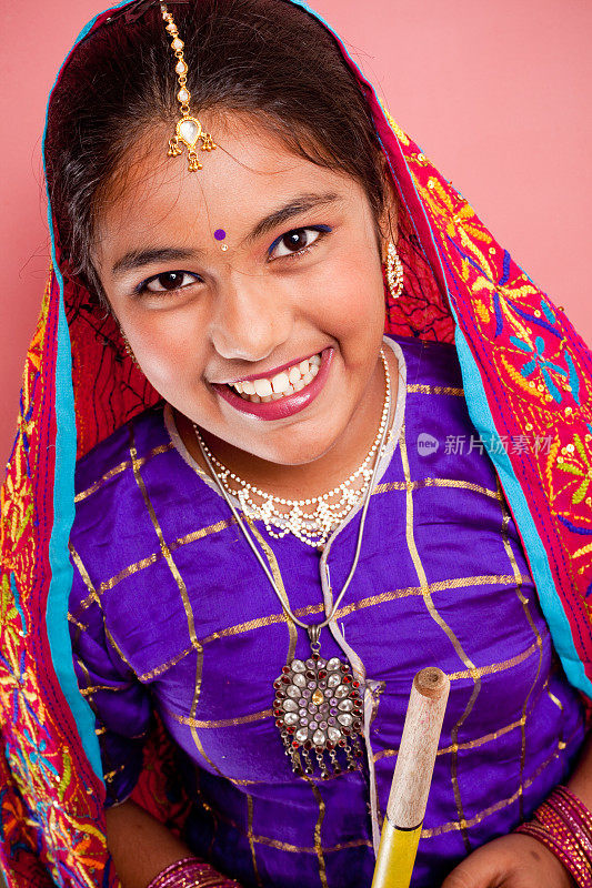兴高采烈的传统印度迷人的美丽少女拿着丹迪亚棒
