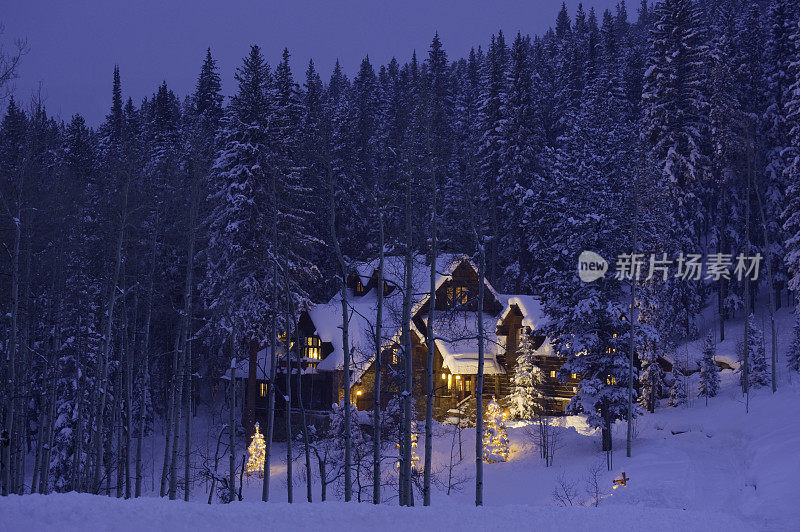 在冬天与新鲜的雪发光的豪华木屋家