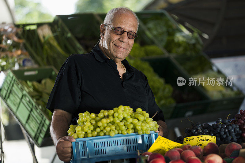 一名男子在露天市场买葡萄