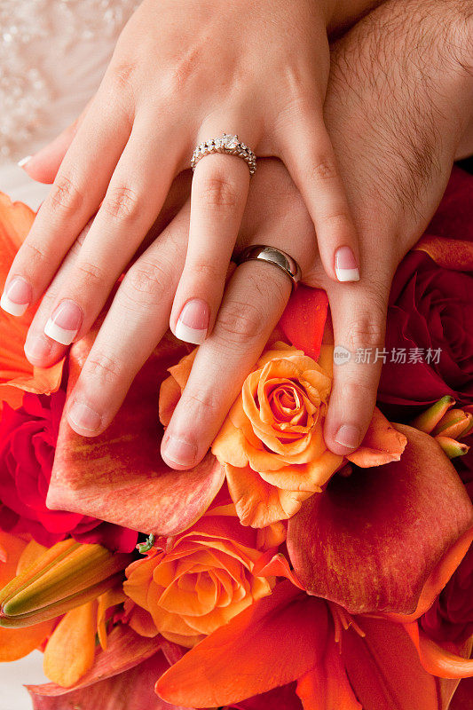 浪漫的新娘和新郎在婚礼花束上展示戒指