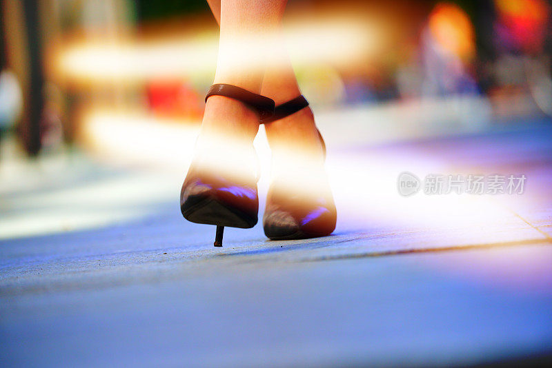 女人穿着漂亮的鞋子，晚上有灯