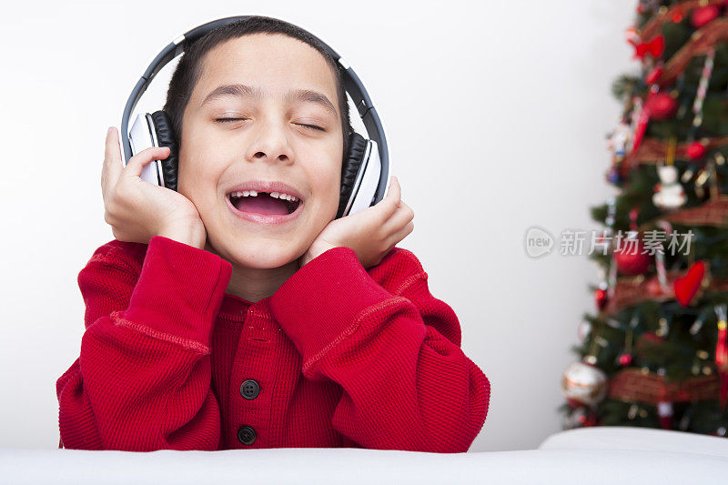 戴着耳机的圣诞微笑男孩