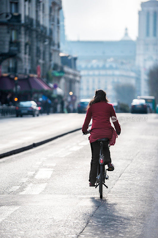 一个法国女人在巴黎大街上骑自行车