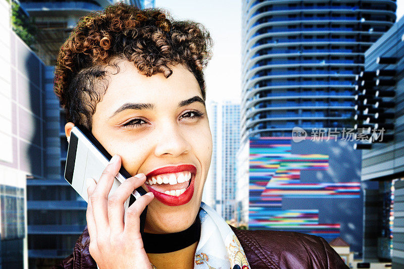 时髦的年轻城市混合种族女性在手机交谈微笑