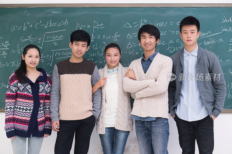一组大学生站在黑板前