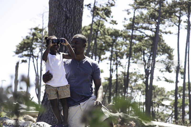 非洲父亲抱着他的女儿在原木上