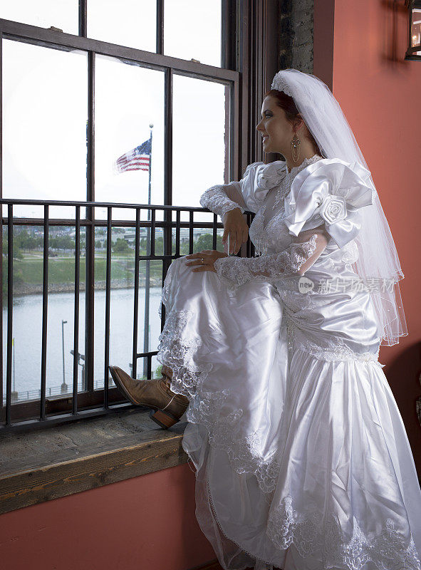 穿着牛仔靴站在橱窗里的美国新娘。